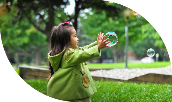 Little girl popping a bubble