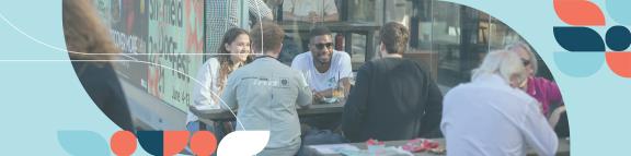 Young people sat around a table socialising