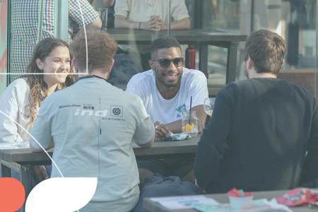 Young people sat around a table socialising